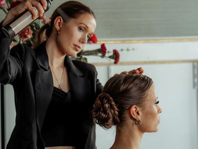 Hårstylist arbetar med håruppsättning